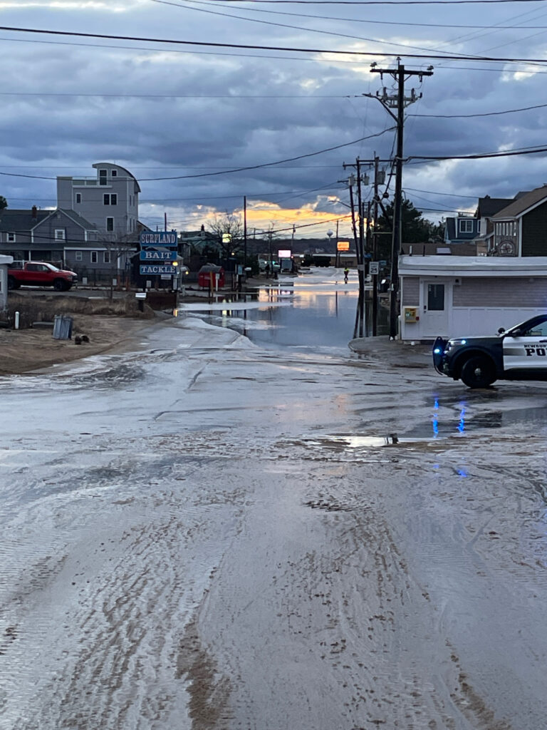 a road with a puddle on the side and buildings on the side (MyCoast AI)
