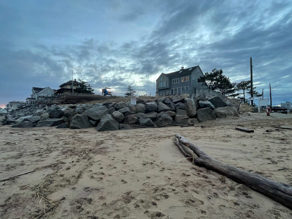 a beach with rocks and a house (MyCoast AI)