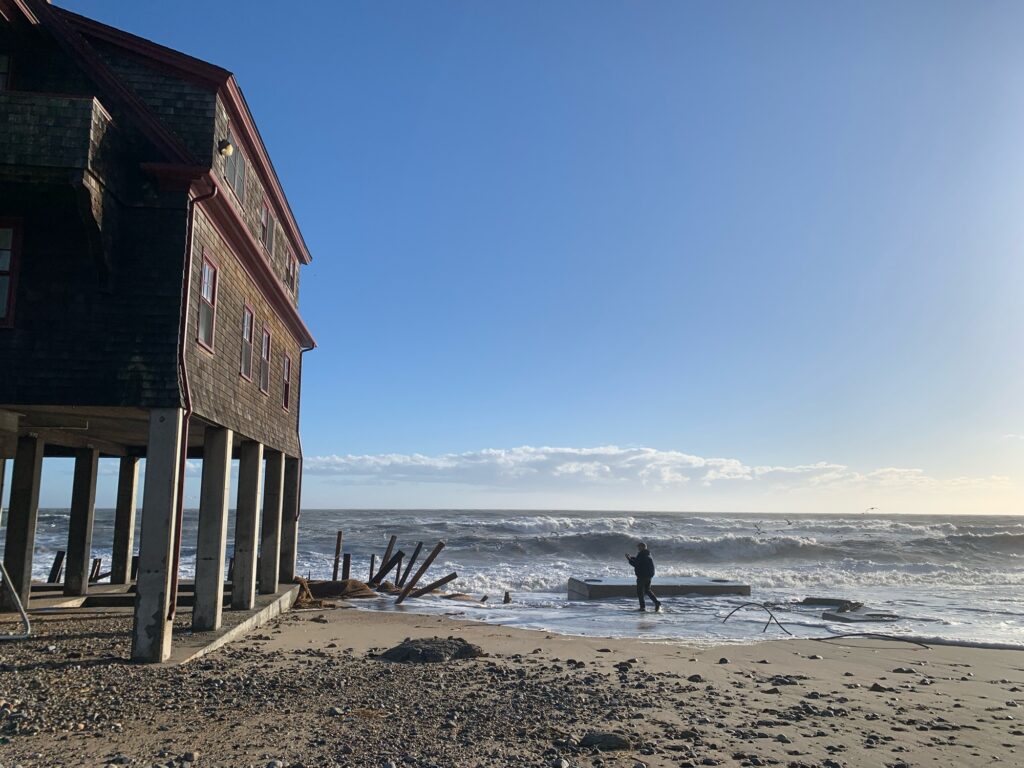 a person holding a surfboard on a beach (MyCoast AI)