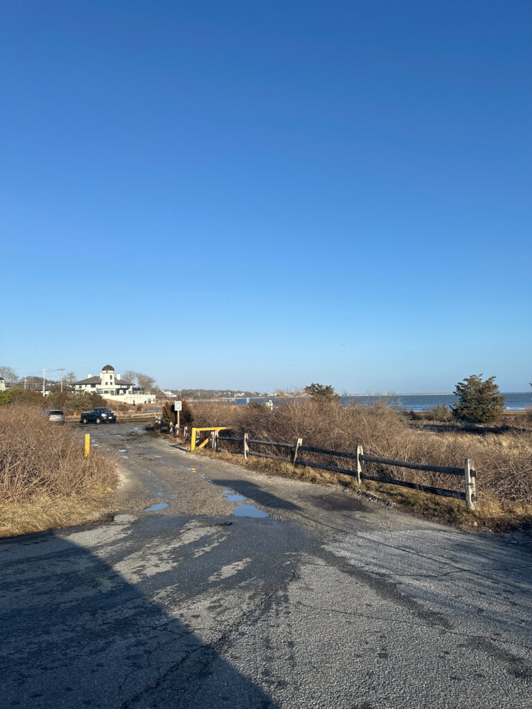 a road with a fence and a building in the distance (MyCoast AI)