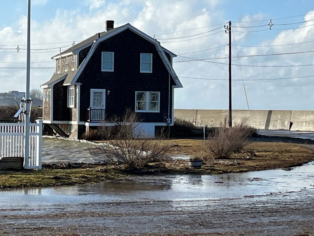 a house with a fence and a road with snow on it (MyCoast AI)