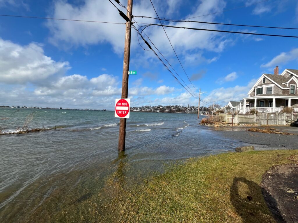 a stop sign on a pole next to a body of water (MyCoast AI)