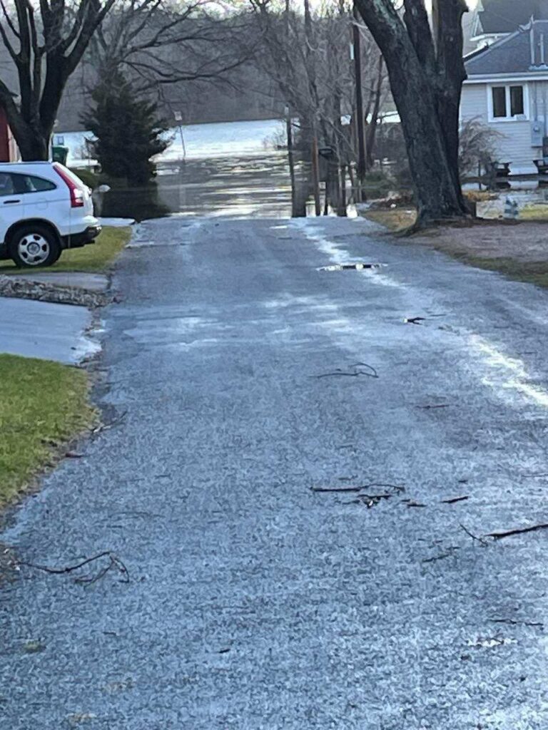 a road with a puddle and a car parked on the side (MyCoast AI)