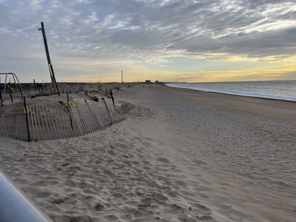 a beach with a fence and a body of water (MyCoast AI)