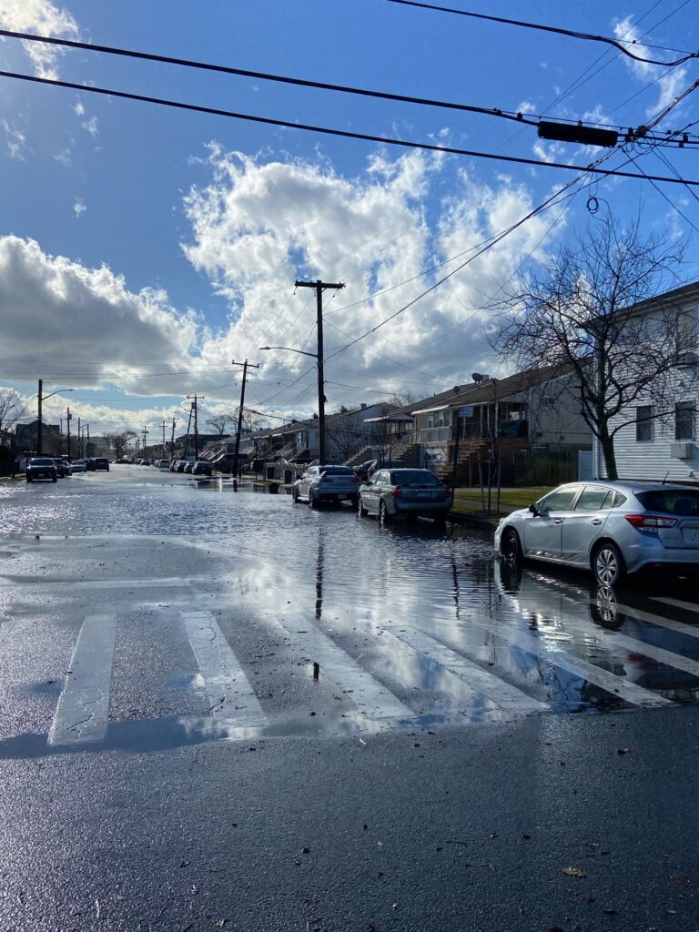 a street with cars parked on the side and buildings on the side (MyCoast AI)