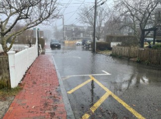 a wet street with cars on it (MyCoast AI)