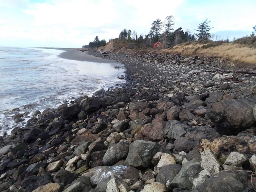 a rocky beach with a red house (MyCoast AI)