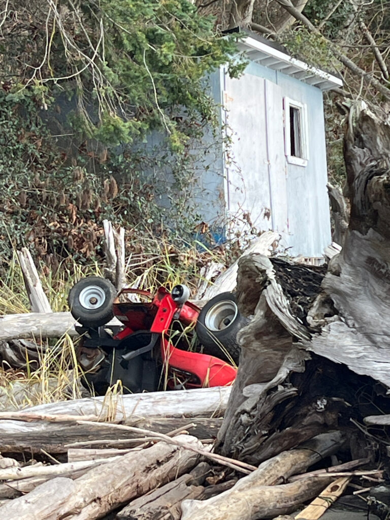 a red lawnmower next to a white house (MyCoast AI)