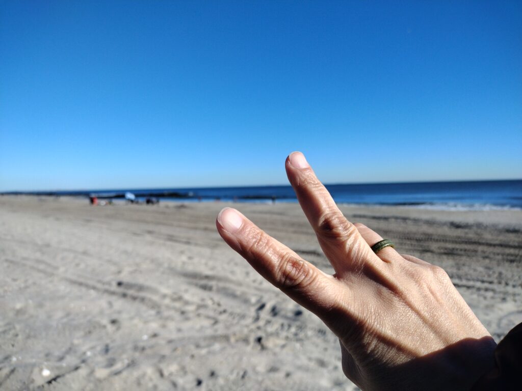 a hand with a ring on a beach (MyCoast AI)