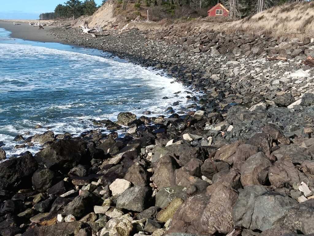 a rocky beach with a red house (MyCoast AI)