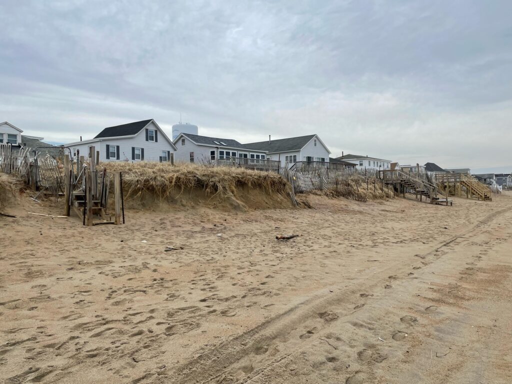 a sandy beach with houses in the background (MyCoast AI)