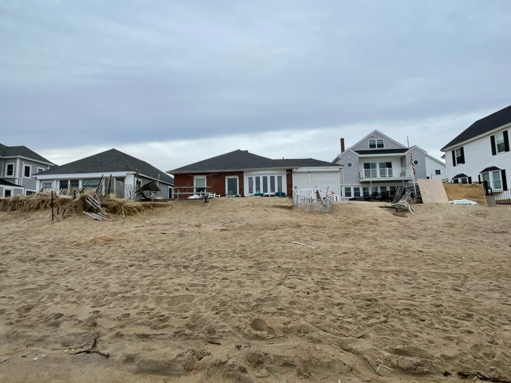 a sandy beach with houses in the background (MyCoast AI)