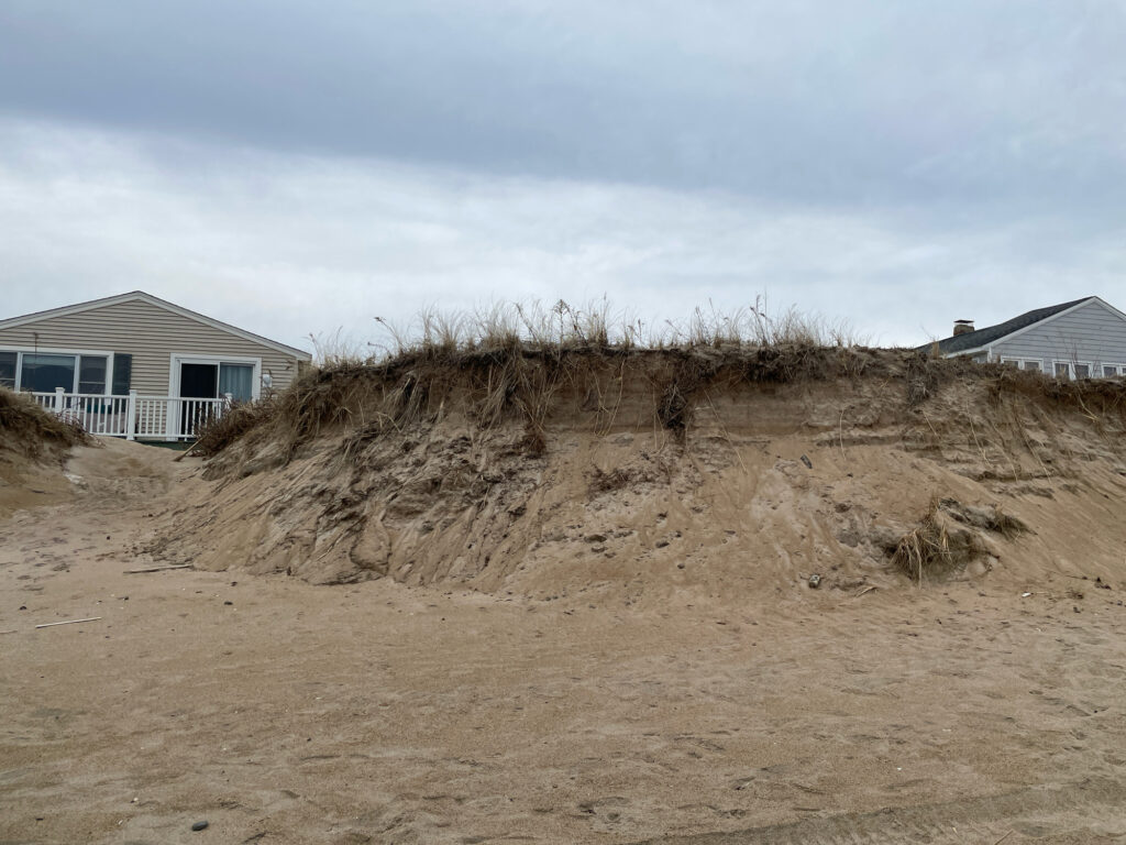 a dirt hill with a house in the background (MyCoast AI)