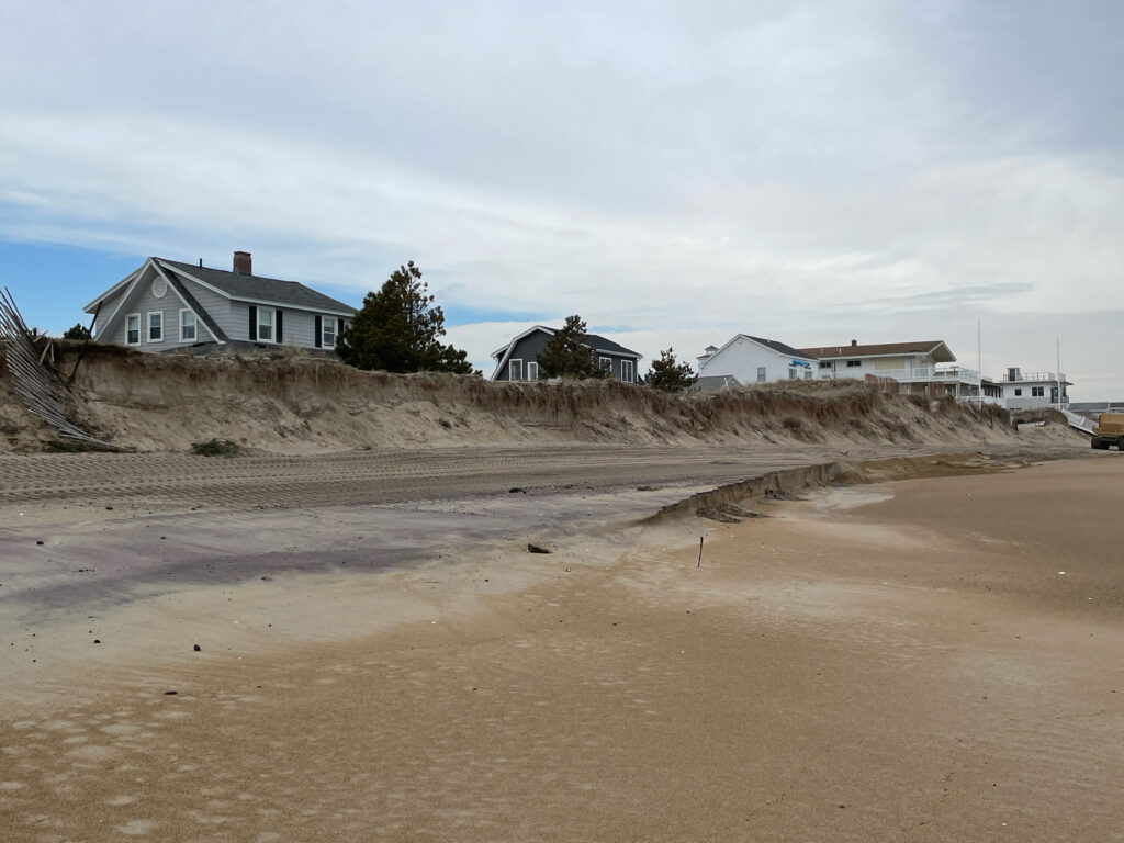 a sandy beach with houses in the background (MyCoast AI)