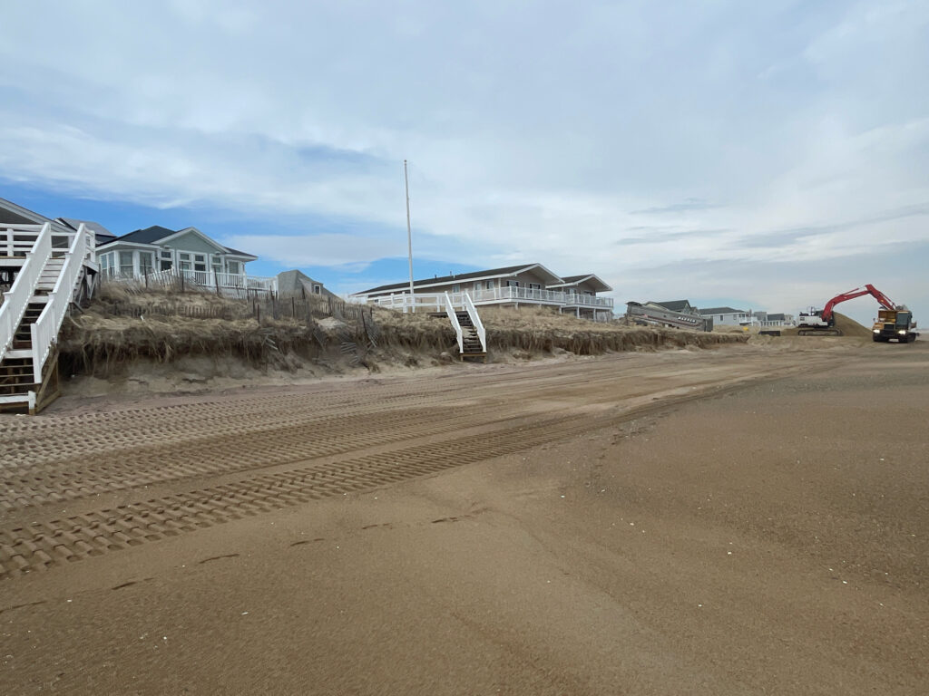 a dirt road with a white fence and a red tent (MyCoast AI)