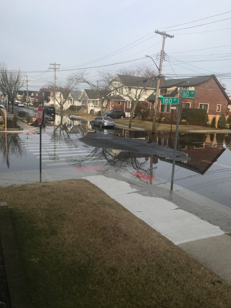 a flooded street with a car driving by (MyCoast AI)