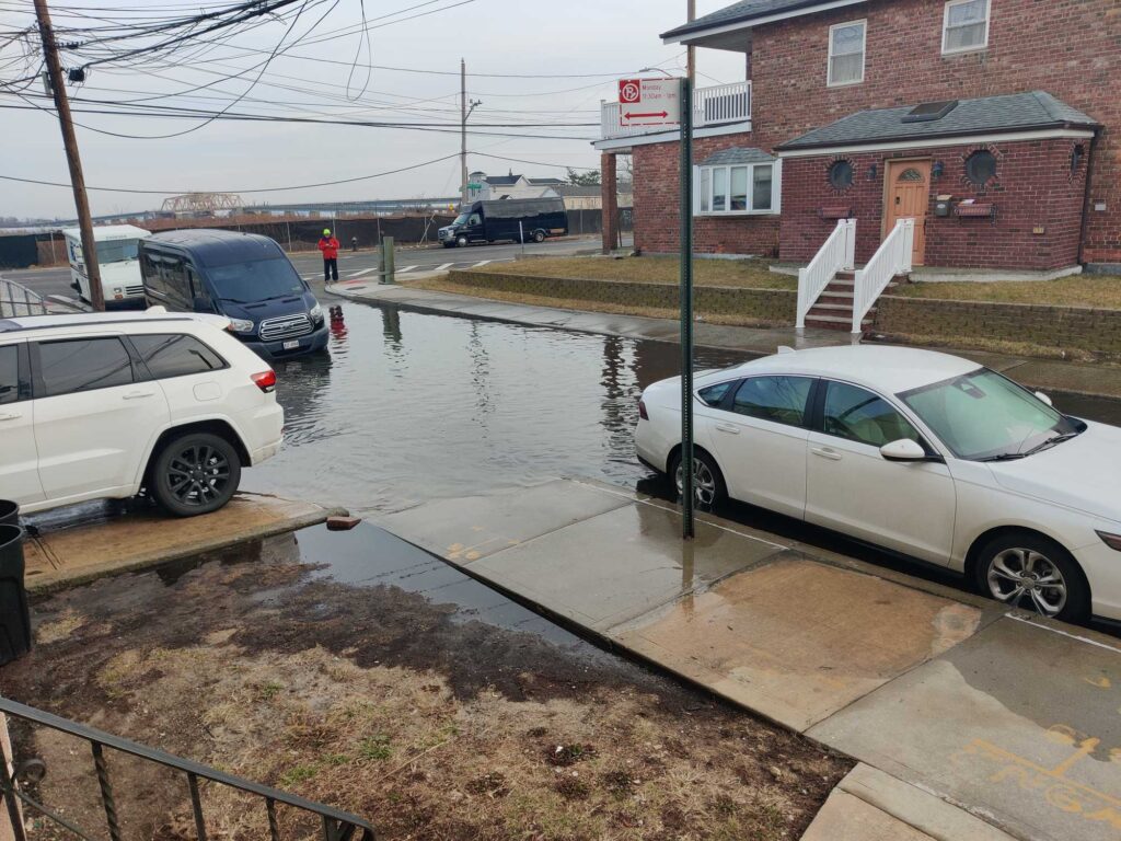 a flooded street with cars and a house (MyCoast AI)