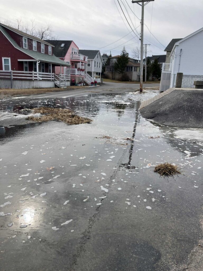 a wet street with houses on either side of it (MyCoast AI)