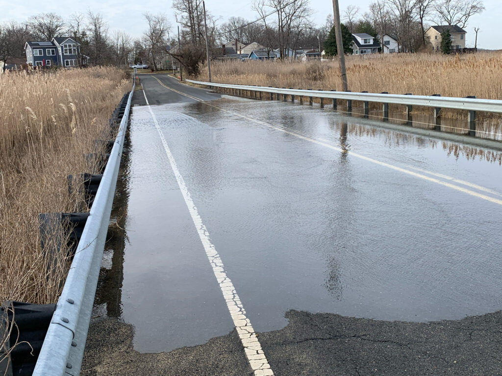 a wet road with a puddle on the side (MyCoast AI)