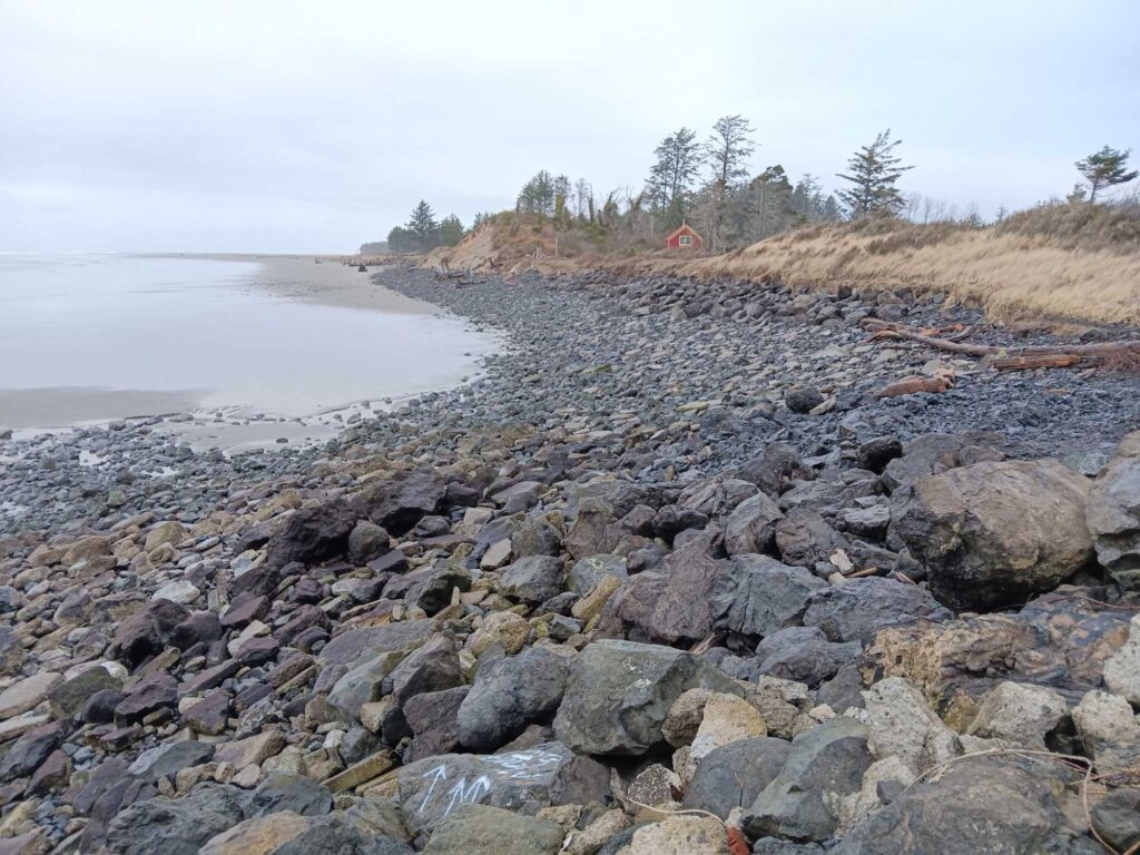a rocky beach with a house in the distance (MyCoast AI)