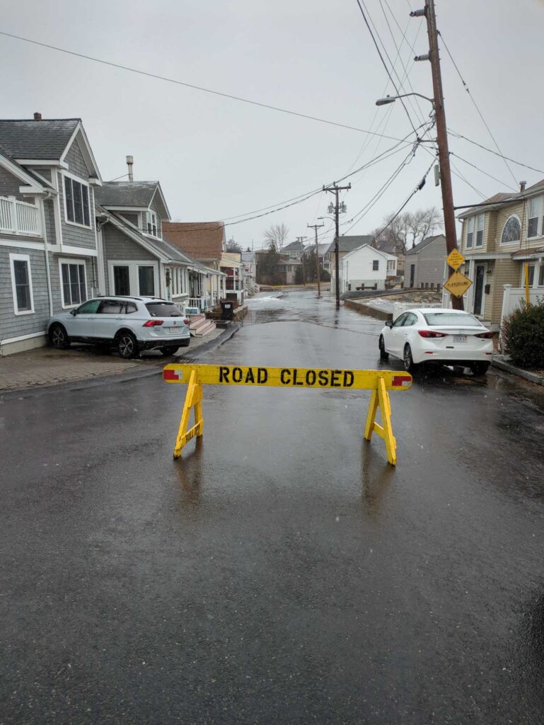 a road with a yellow tape on it and a white car parked on the side (MyCoast AI)