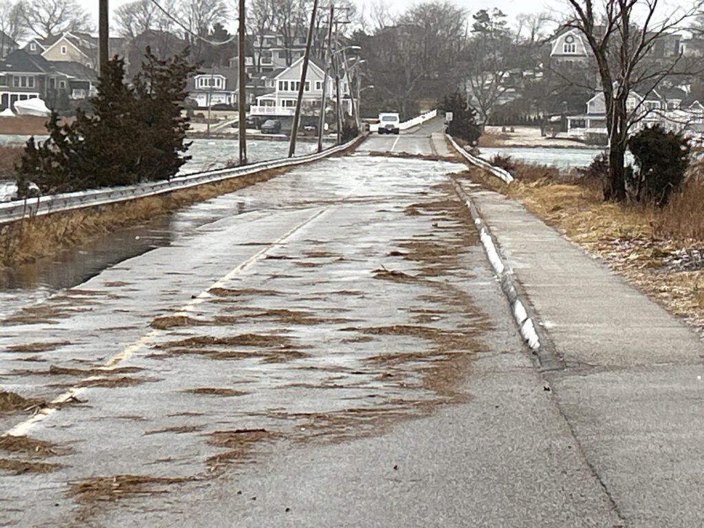 a wet road with houses on either side of it (MyCoast AI)