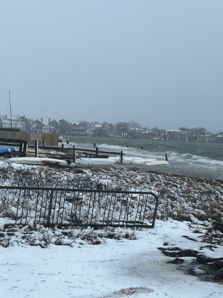 a snowy beach with a fence and a city in the background (MyCoast AI)
