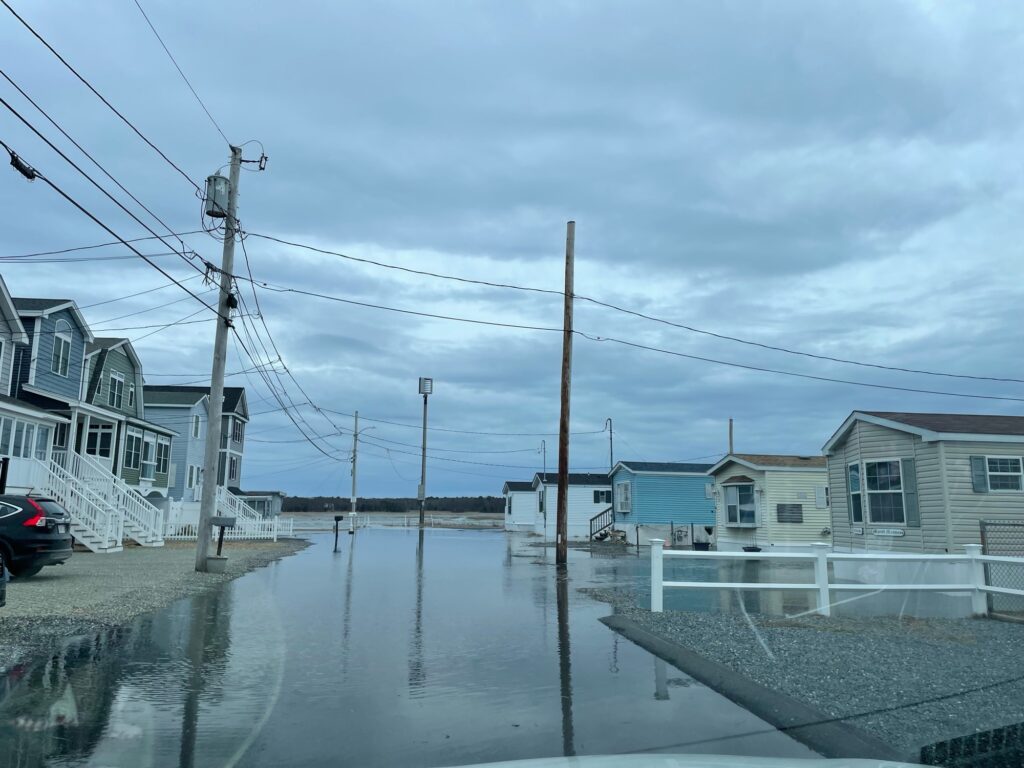 a flooded street with houses and power lines (MyCoast AI)