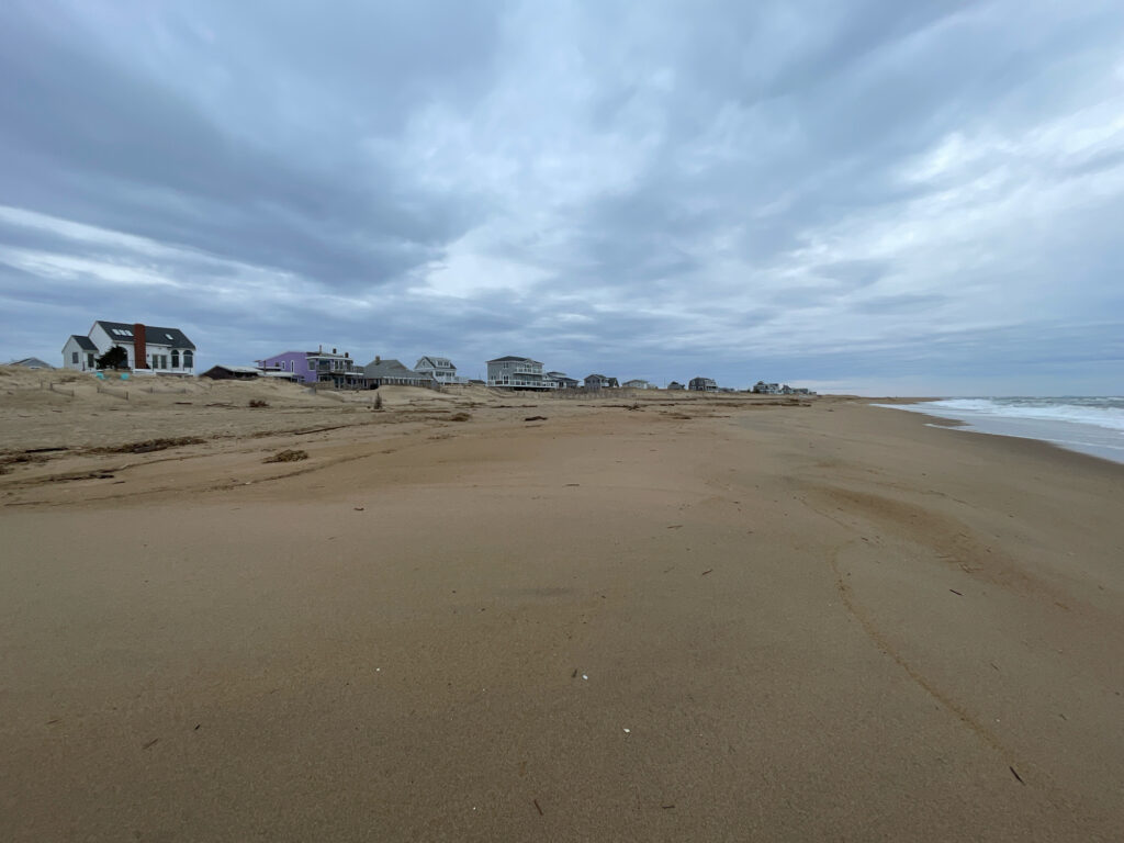 a sandy beach with buildings in the distance (MyCoast AI)