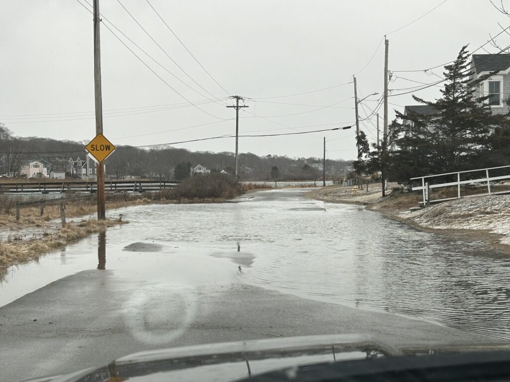 a flooded street with a yellow sign (MyCoast AI)
