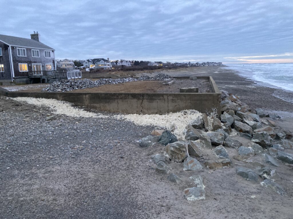 a rocky beach with a building in the background (MyCoast AI)