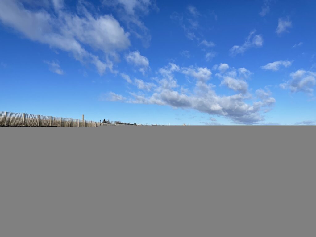 a field with a fence and blue sky (MyCoast AI)