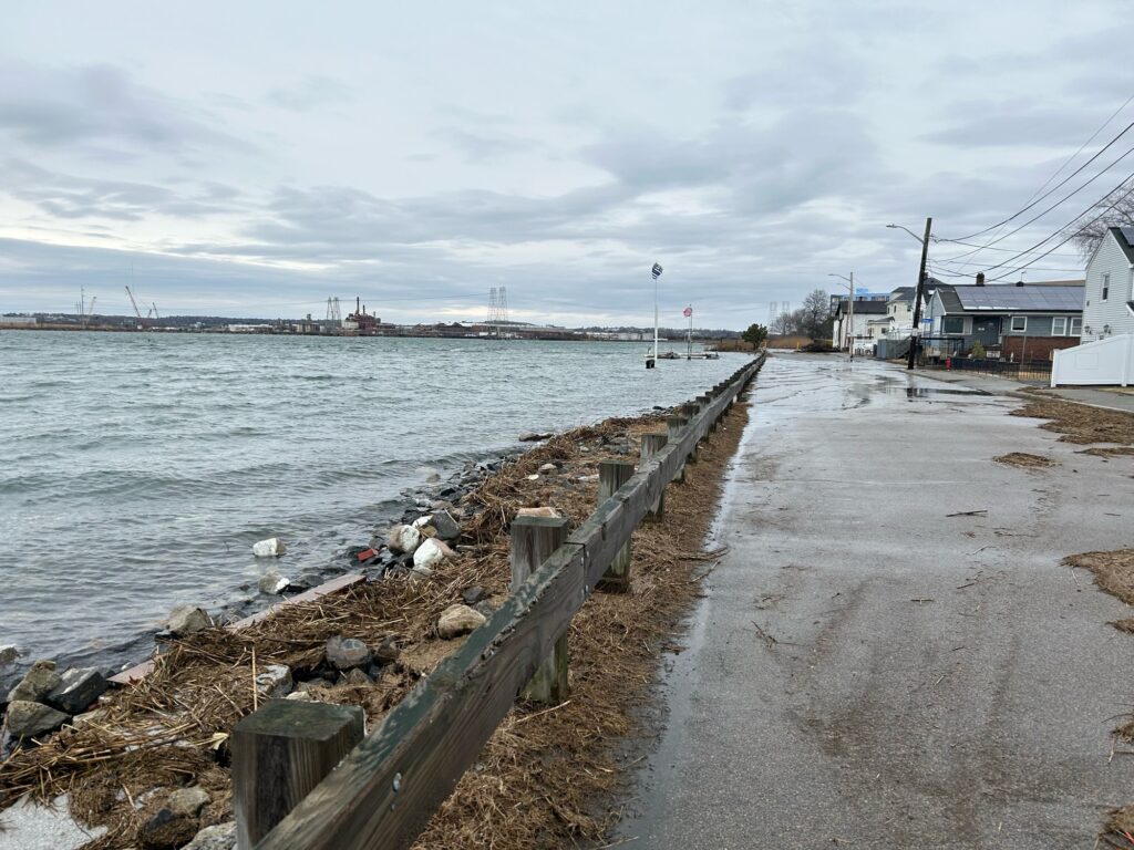 a path next to a body of water with a dock and buildings (MyCoast AI)
