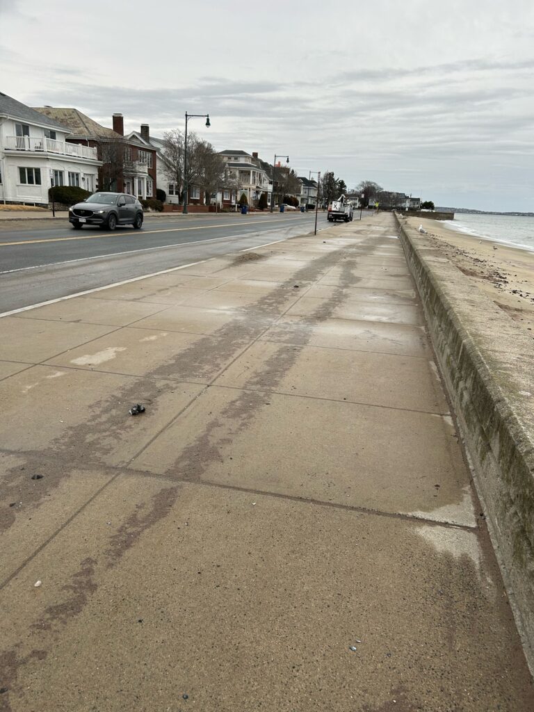 a road with cars on it by a beach and houses (MyCoast AI)