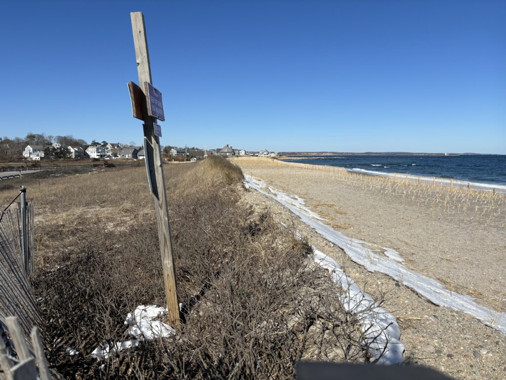 a beach with a fence and a road with snow (MyCoast AI)