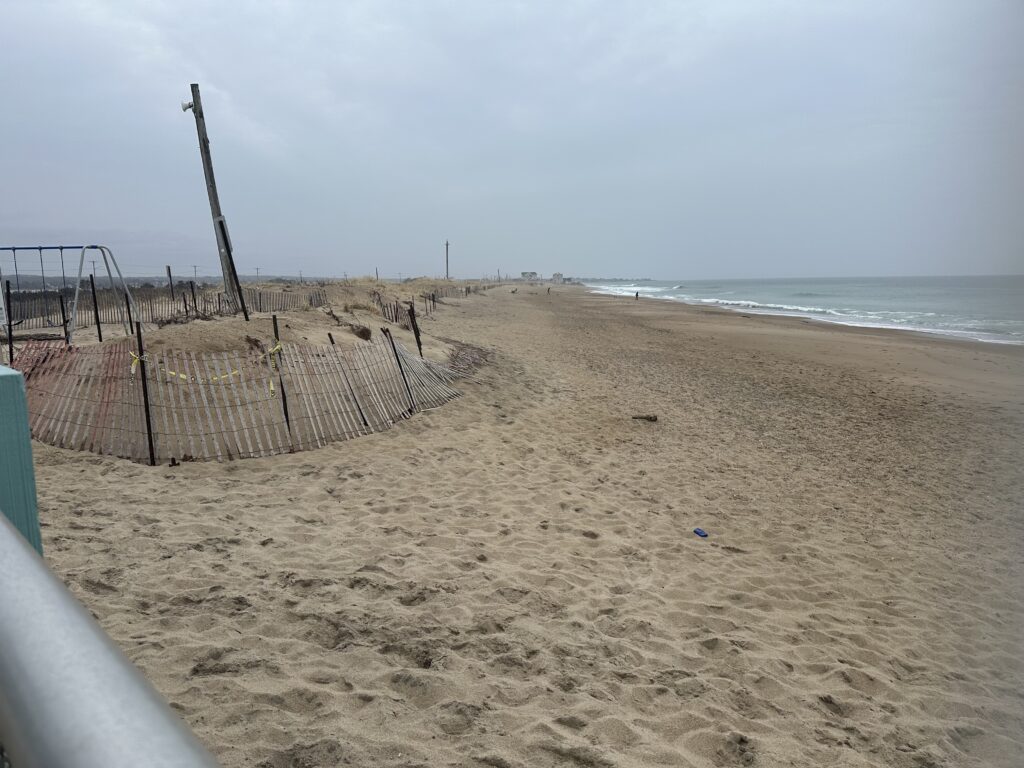 a beach with a fence and a body of water in the background (MyCoast AI)