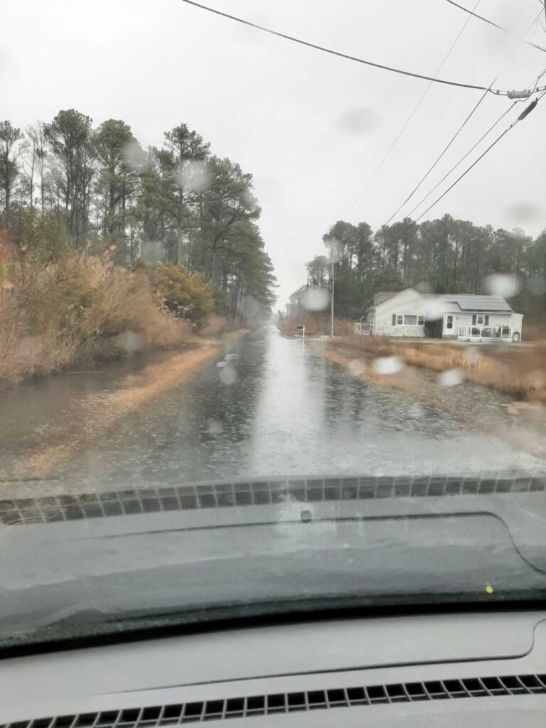 a flooded road with a house and trees on the side (MyCoast AI)