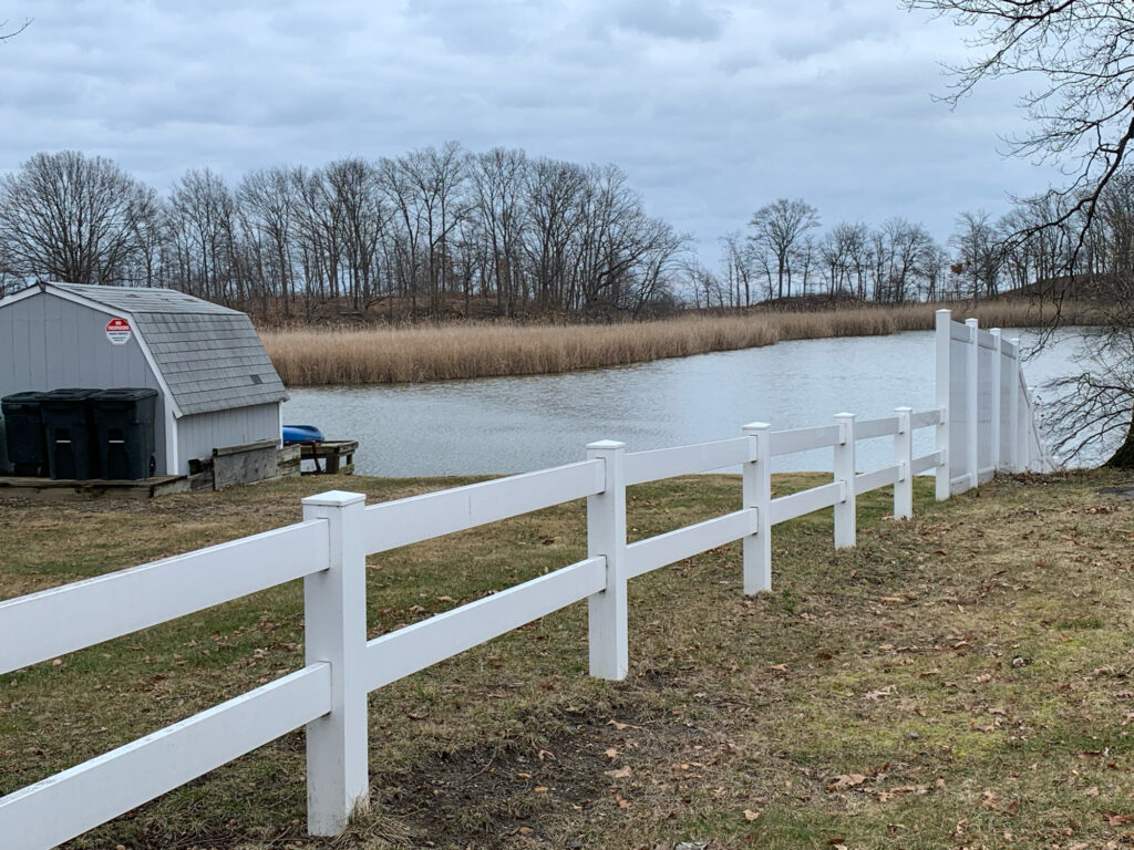 a white fence next to a river (MyCoast AI)