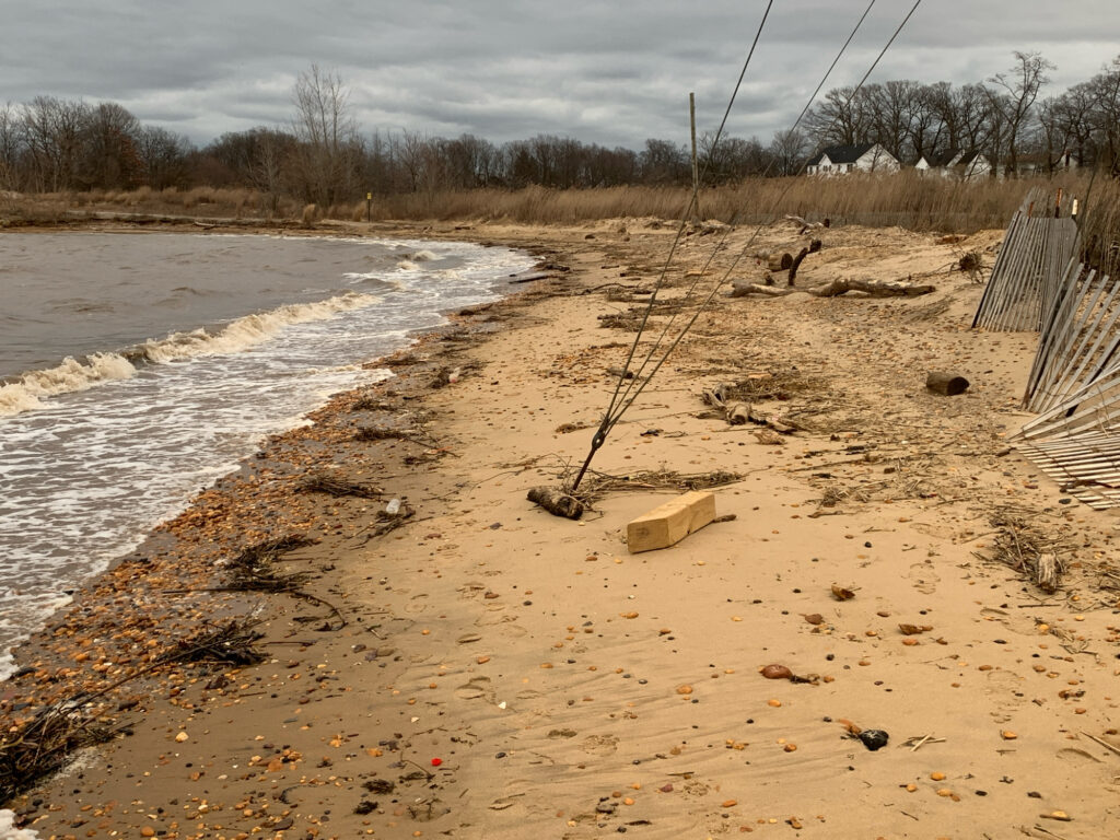 a muddy area with a fence and a body of water (MyCoast AI)