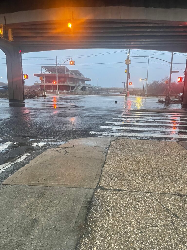 a wet street with a bridge (MyCoast AI)