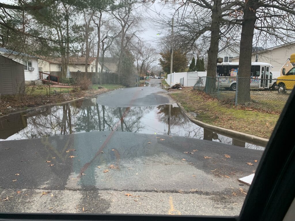 a flooded street with a van and trees (MyCoast AI)