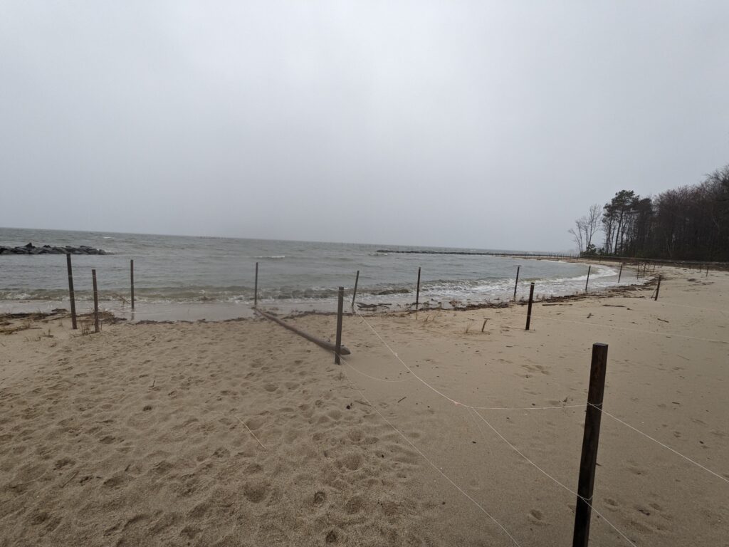 a beach with a fence and a body of water in the background (MyCoast AI)
