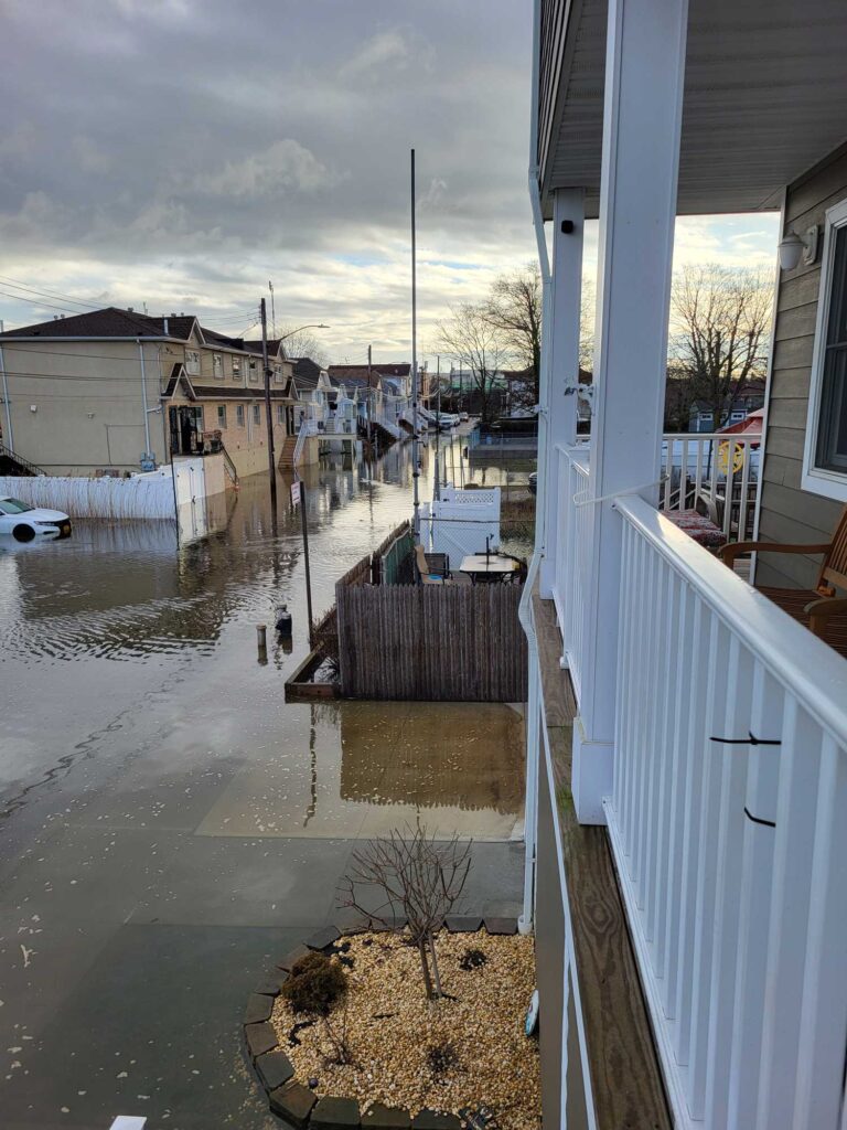 a flooded street with a white fence (MyCoast AI)