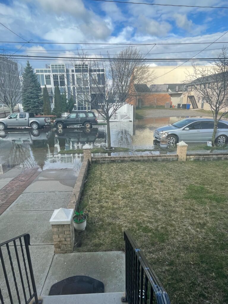 a yard with a puddle and cars parked in it (MyCoast AI)