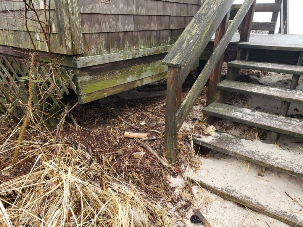a pile of hay next to a wooden fence (MyCoast AI)