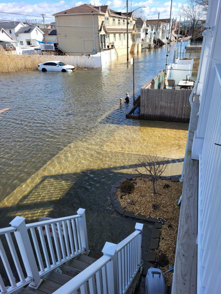 a flooded street with a car parked on the side (MyCoast AI)
