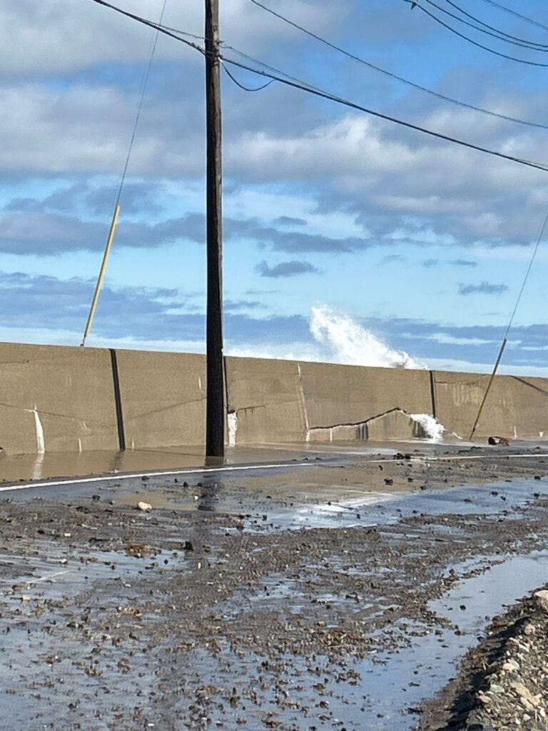a road with a wall and power lines on the side (MyCoast AI)