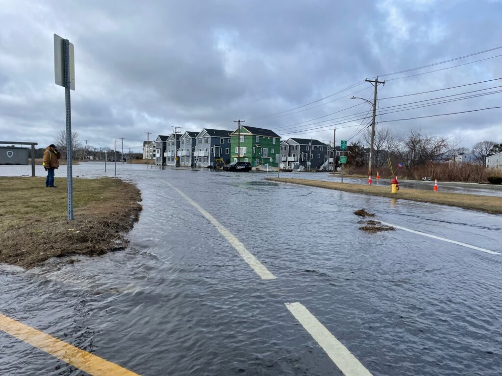 a road with a puddle on the side and buildings on the side (MyCoast AI)