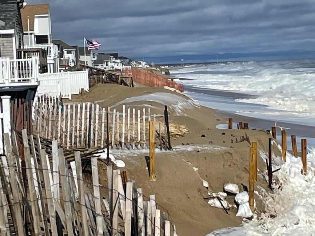 a beach with a fence and a building with a flag on it (MyCoast AI)