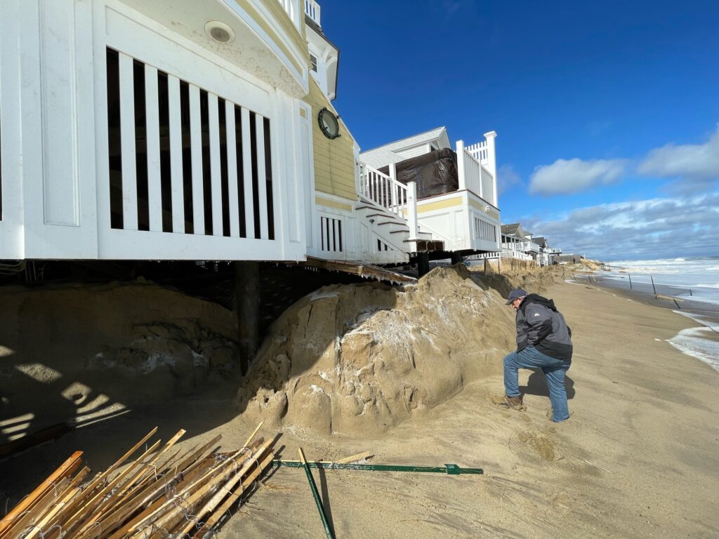 a man standing on a pile of dirt next to a building (MyCoast AI)
